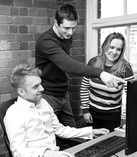 GWD team members in discussion around a computer