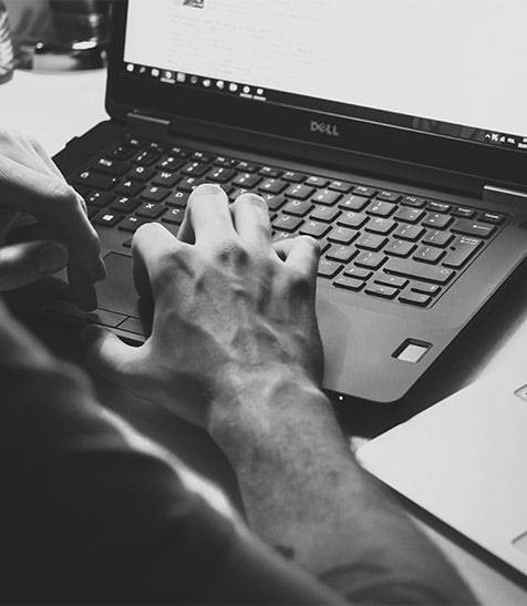 Hands typing on laptop in black and white image