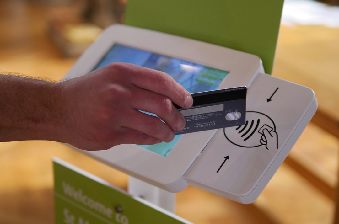 photo showing someone using a credit card to make a contactless donation